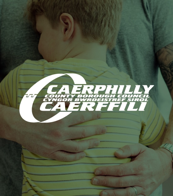 An image of a child embracing an adult overlapped by the Caerphilly Council logo